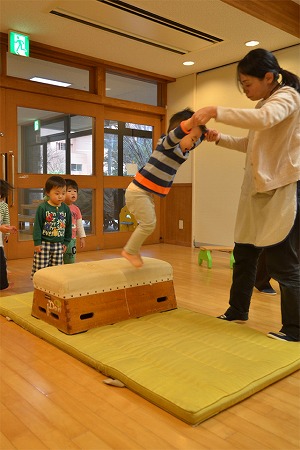 写真：手を添えてあげて跳び箱ジャンプ