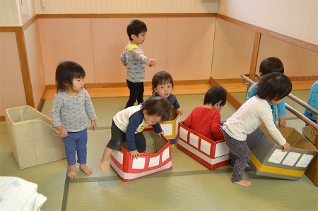 写真：電車段ボールボックスで遊ぶ子どもたち