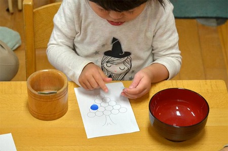 写真：円形カラーシールを貼る子ども2