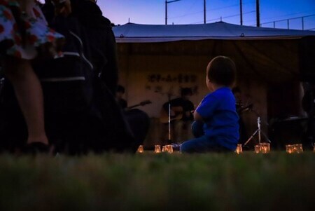 写真：夕暮れ時にステージを見る子ども