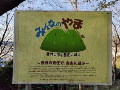 写真:緑地にある看板(みんなのやま 自然の中を自由に遊ぶ 自分の責任で、自由に遊ぶ)